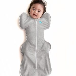 Baby in gray Love To Dream swaddle sack, arms up.